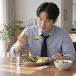 아침 식사 자리에서 물 한 잔과 작은 스틱 포를 둔 직장인