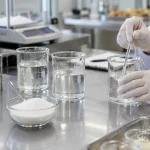 식품 실험실 작업대의 자당 용액 비커와 설탕 그릇